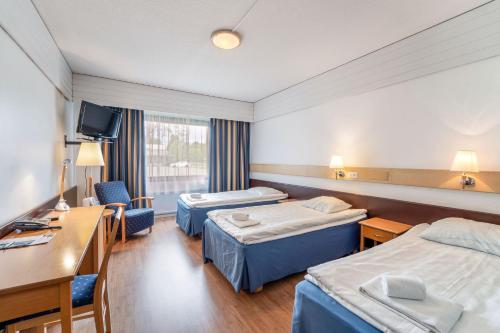 Habitación de hotel con 2 camas y escritorio en Hotelli Sodankylä, en Sodankylä