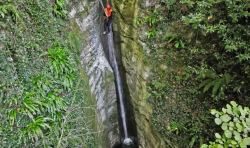 a person in a red jacket on a rock wall at La Locanda del Moro in Pieve Fosciana