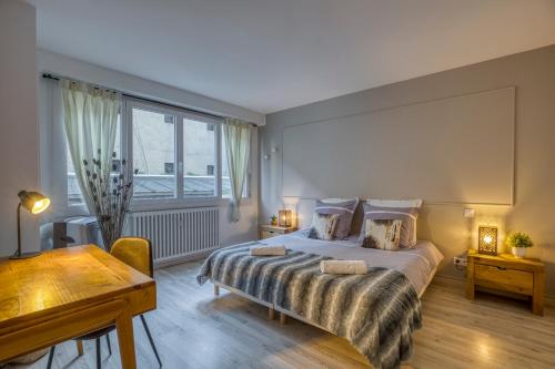 une chambre avec un grand lit et un bureau dans l'établissement Charmant T3 - centre ville - proche du lac, à Annecy