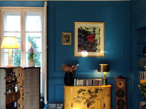 a room with blue walls and a table with a lamp at CHATEAU DE BRINVILLE in Saint-Sauveur-sur-École