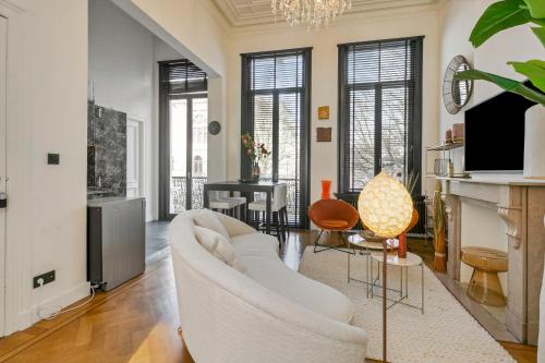 a living room with a white couch and a tv at Museum Garden View Apartment Antwerp South in Antwerp