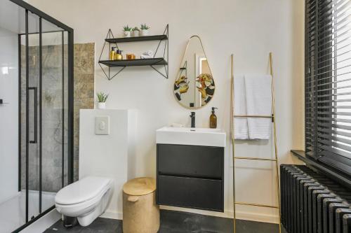 a bathroom with a toilet and a sink and a mirror at Museum Garden View Apartment Antwerp South in Antwerp