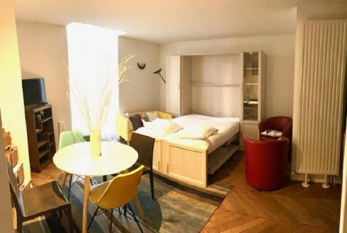 a bedroom with a bed and a table and a room at Appartement centre Vichy in Vichy