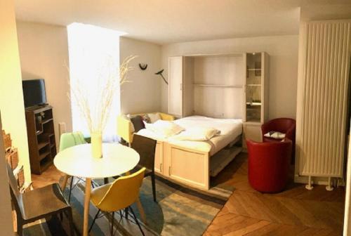 ヴィシーにあるAppartement centre Vichyのベッドルーム1室(ベッド1台、テーブル付)、