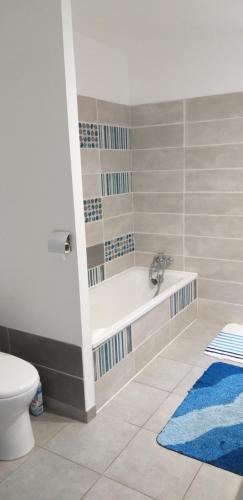 a bathroom with a bath tub and a toilet at Chez Reinette in Capendu