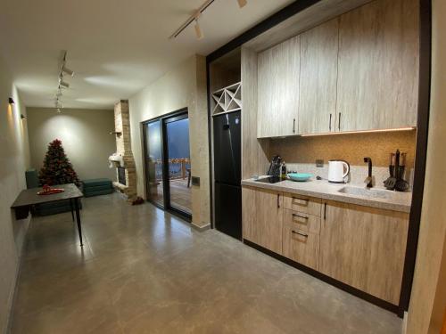 a kitchen with wooden cabinets and a christmas tree in it at Runaway House - Qalacıq in Gabala