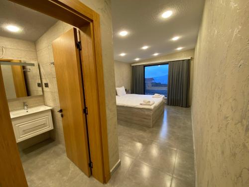 a bedroom with a bed and a bathroom with a window at Runaway House - Qalacıq in Gabala