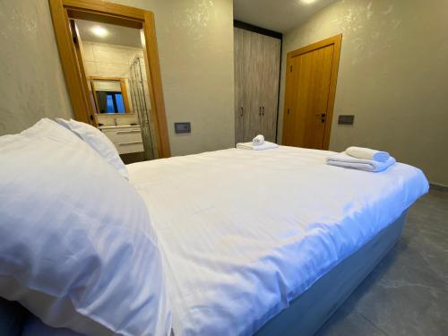 a large white bed with towels on top of it at Runaway House - Qalacıq in Gabala