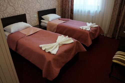 two beds in a hotel room with towels on them at BeSt Hotel and Restaurant complex in Dunaivtsi