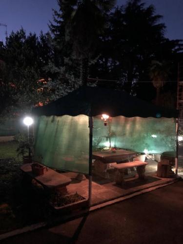 a tent with a picnic table in a yard at night at Casa Stella Malpensa in Cassano Magnago