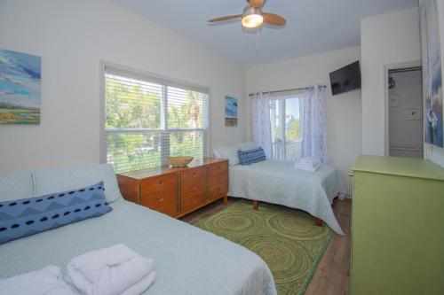 a bedroom with two beds and a window at 619 Porpoise Circle in St. Helena Island