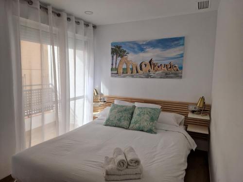 a bedroom with a bed with towels on it at Pavone Apartments Málaga in Málaga