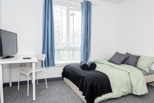 a bedroom with a bed and a desk and a window at Shirley House 3, Guest House, Self Catering, Self Check in with Smart Locks, Use of Fully Equipped Kitchen, close to City Centre, Ideal for Longer Stays, Walking Distance to BAT, 20 min Drive to Fawley Refinery, Excellent Transport Links in Southampton