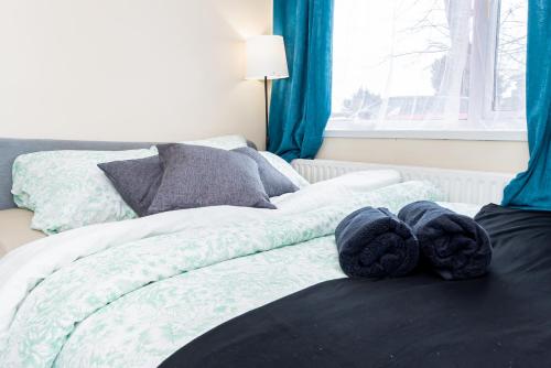 a bedroom with two beds with blue curtains and pillows at Shirley House 3, Guest House, Self Catering, Self Check in with Smart Locks, Use of Fully Equipped Kitchen, close to City Centre, Ideal for Longer Stays, Walking Distance to BAT, 20 min Drive to Fawley Refinery, Excellent Transport Links in Southampton