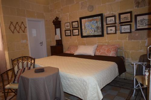 a bedroom with a bed and a table in it at Maria Townhouse Heart of Victoria B&B in Victoria