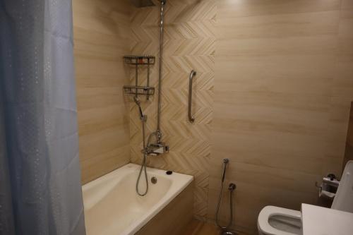 a bathroom with a bath tub and a shower at Hayyat Luxury Hotel Apartments in Lahore
