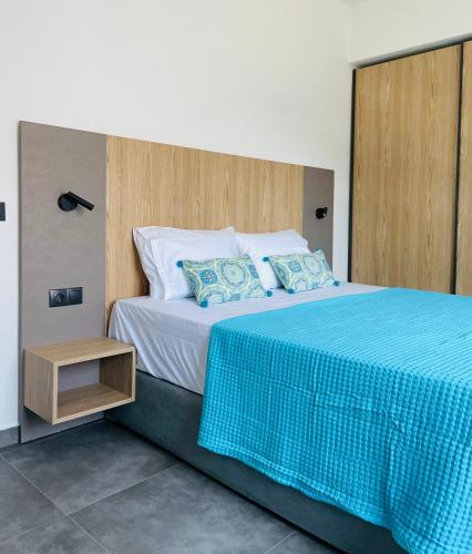 a bedroom with a large bed with a blue blanket at GEMINI VILLAS NIKITI in Nikiti