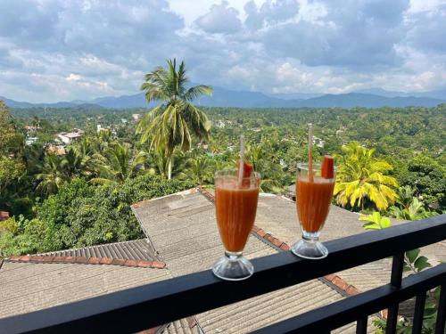 Duas bebidas numa varanda com vista para a cidade em Dreamscape home stay em Kandy