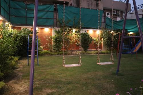 a playground with swings in a yard at night at Hayyat Luxury Hotel Apartments in Lahore