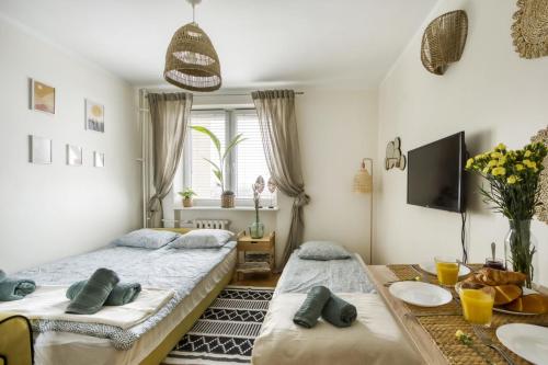 - une chambre avec 2 lits et une table avec des plaques de cuisson dans l'établissement Boho Dream, à Varsovie