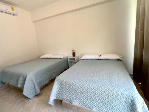 two beds sitting next to each other in a room at Gran Palma Residencial in Acapulco