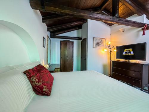 1 dormitorio con cama blanca y almohada roja en Luxury house Corte dei Galati, en Galatone
