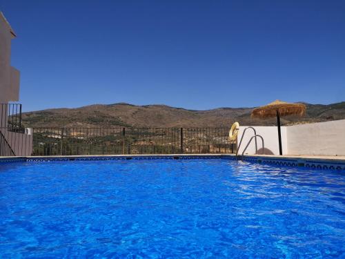 una gran piscina con sombrilla y sombrilla en Los Olivos de Fondon, en Fondón