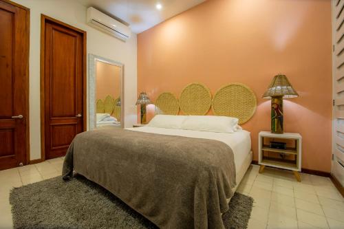 ein Schlafzimmer mit einem großen Bett und einem großen Spiegel in der Unterkunft San Pedro Claver Luxury in the walled city in Cartagena de Indias