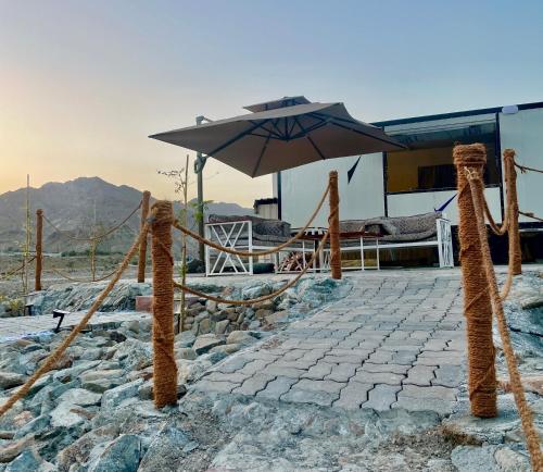 a patio with an umbrella and a table at Al shalal caravan in Fujairah