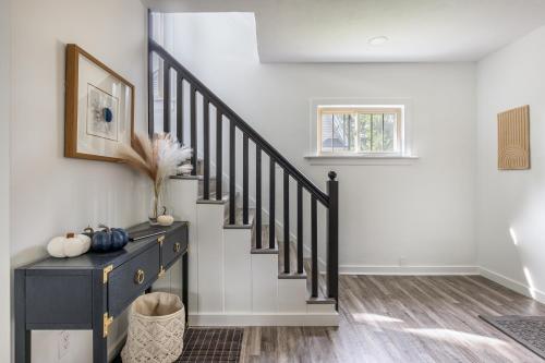 a hallway with a staircase with black railings at The Akron Retreat: Modern 3-Bedroom Oasis in Akron
