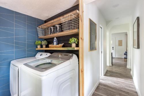 a washing machine in a laundry room with blue tiles at The Akron Retreat: Modern 3-Bedroom Oasis in Akron