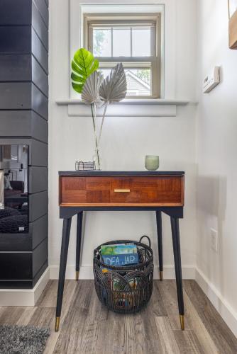a table in a room with a basket under a window at The Akron Retreat: Modern 3-Bedroom Oasis in Akron