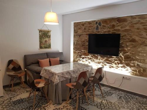 uma sala de estar com uma mesa e um sofá em Casa Rural Los Naranjos em Constantina