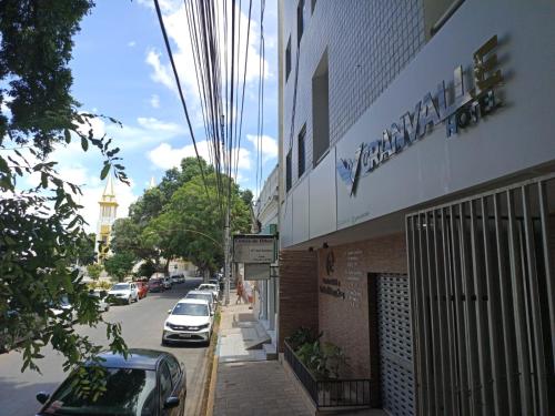 a street with cars parked in front of a building at Granvalle Hotel Juazeiro in Juazeiro