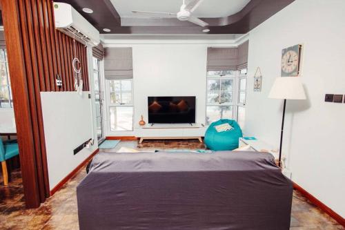 En TV eller et underholdningssystem på Charming Beachfront 2BR Apartment in Hulhumale’