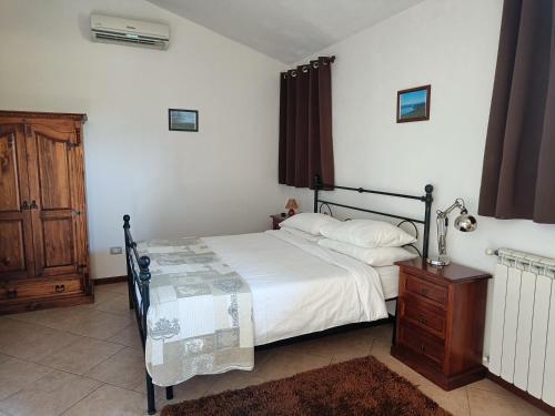 a bedroom with a bed and a wooden dresser at Agriturismo Fontelupo in Bracciano