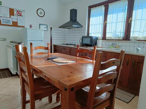 - une cuisine avec une table en bois, des chaises et une cuisinière dans l'établissement Agriturismo Fontelupo, à Bracciano