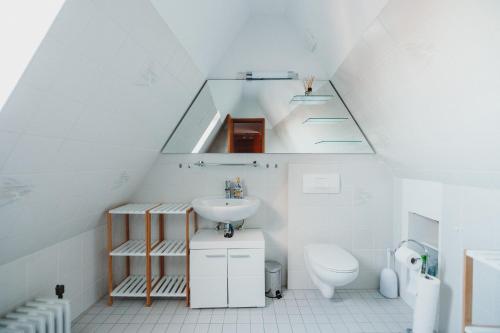 ein weißes Bad mit einem Waschbecken und einem WC in der Unterkunft Ferienwohnung Oberhausen Sterkrade in Oberhausen
