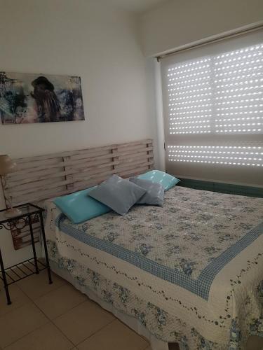 1 dormitorio con 1 cama con 2 almohadas y ventana en Lo de Lili en Mar del Plata