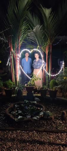 a group of three people standing in a garden at night at Kuttickattil Gardens Homestay in Kottayam