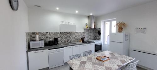 - une cuisine avec des appareils électroménagers blancs et une table dans l'établissement 