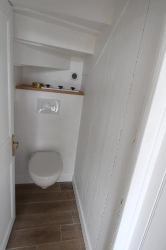 une salle de bain avec des toilettes blanches dans une chambre dans l'établissement Maison de pêcheur, à Combrit