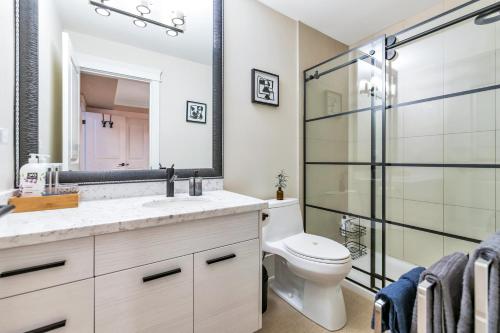 a bathroom with a sink and a toilet and a mirror at Boutique in Vancouver