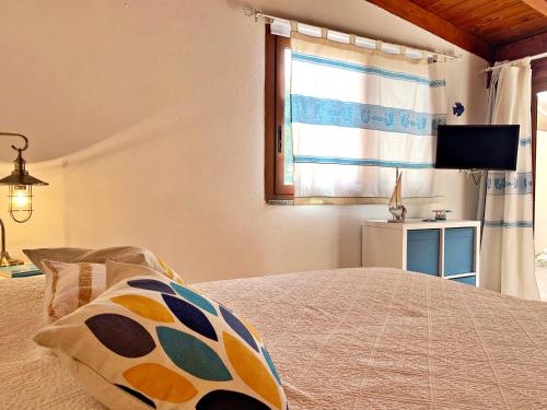 a bedroom with a bed with a window and a television at DomoMea - Le Gioie di Laura in Su Forti