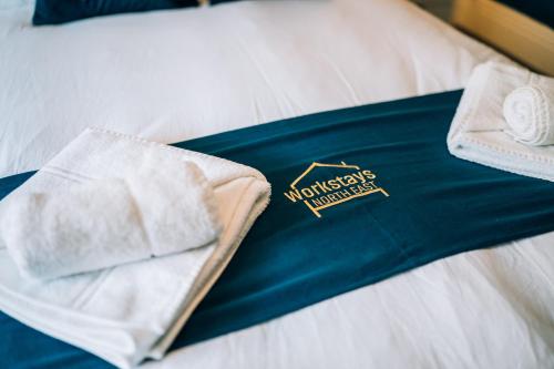 een blauw dienblad met handdoeken op een bed bij Freda House By Horizon Stays in Sunderland