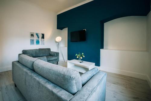 een woonkamer met een bank en een tv bij Freda House By Horizon Stays in Sunderland