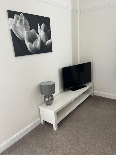 a tv sitting on a white cabinet in a room at Dunelm House in Seahouses