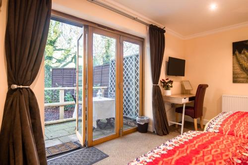 una camera da letto con una porta che si apre su un balcone di Terlingham Lane Cottage a Folkestone