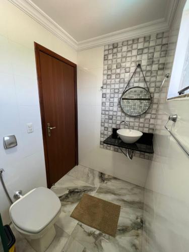 a bathroom with a toilet and a sink at Casa Luz - triplex com piscina in Foz do Iguaçu