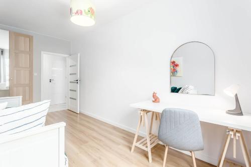 a white room with a desk and a mirror at Enjoy! Ursus in Warsaw